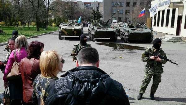 Местные жители стоят возле вооруженных людей, охраняющих БТР в Славянске Местные жители стоят возле вооруженных людей, охраняющих БТР в Славянске