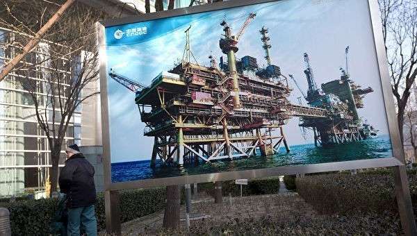 Баннер с изображением китайской нефтяной платформы компании CNOOC в Пекине. Архивное фото Баннер с изображением китайской нефтяной платформы компании CNOOC в Пекине. Архивное фото